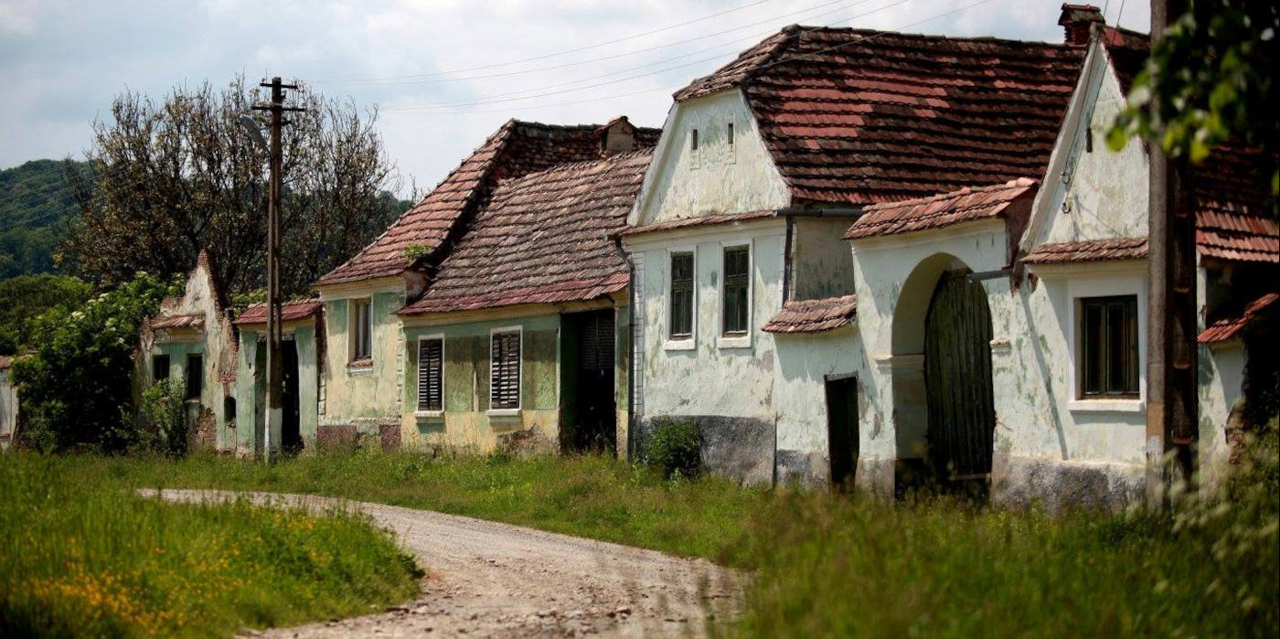 Verfallene sächsische Häuserzeile im fast verlassenen Dorf Gherdeal (Gürteln) in Siebenbürgen mit bröckelnden Fassaden.