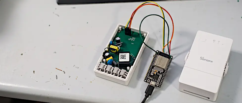 Sonoff POWR316 Tasmota flashen: geöffneter Sonoff POWR316, über vier Jumperkabel mit einem ESP32-Devboard verbunden, daneben das geschlossene Gerät